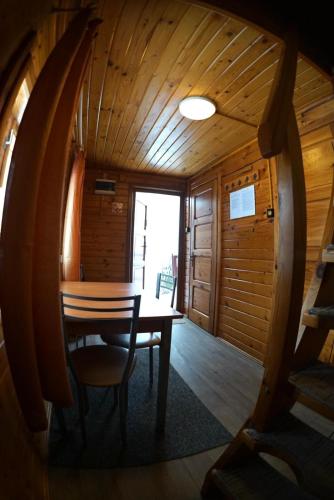 a wooden dining room with a table and chairs at Chata pod Pustą in Wierchomla Mała
