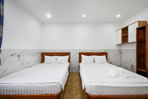 two beds sitting next to each other in a room at Yoyo Airport Saigon Hotel in Ho Chi Minh City