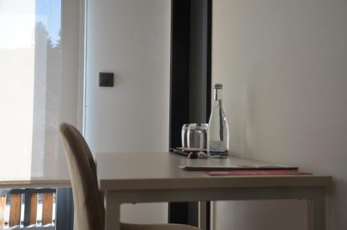 a table with a bottle of wine and a glass at Alma Candida 21 in Valença