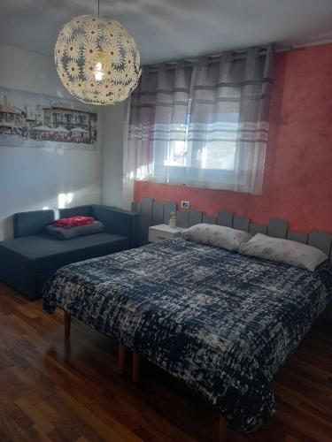 a bedroom with a bed and a couch and a chandelier at Da Chris e Lisa in Trento