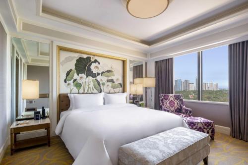 a bedroom with a large bed and a large window at Dusit Thani Manila in Manila