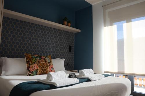 a bedroom with blue walls and two beds with towels at Alma Candida 21 in Valença