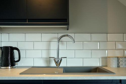a kitchen sink with a faucet on a counter at The Willow - Studio 23 in Bristol