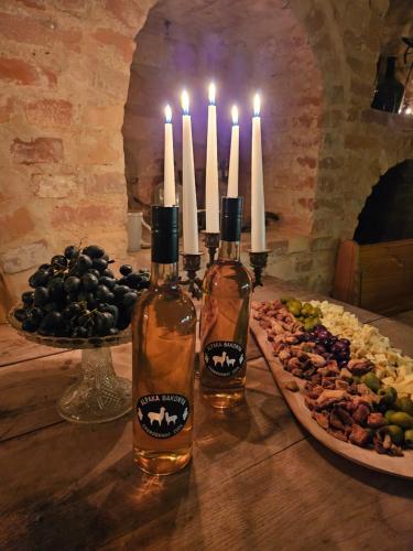 a table with two bottles of wine and a plate of food at Alpaka Bakonya Faház in Bakonya