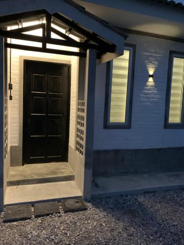 a blue house with a black door and windows at RumaTisa in Teluk Intan