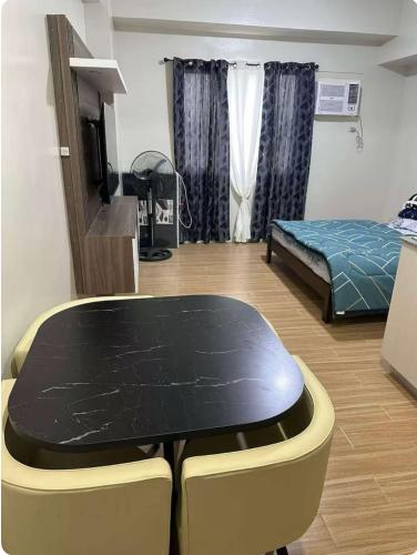 a room with a table and a bed in it at Tulip Garden Apricot Southwoods Binan 1BR with Pool & gym in Biñan