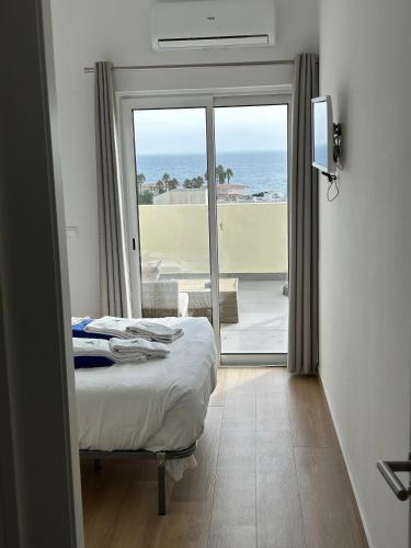 a bedroom with a bed and a view of the ocean at Magnolia Mar Apartamentos in Lagos