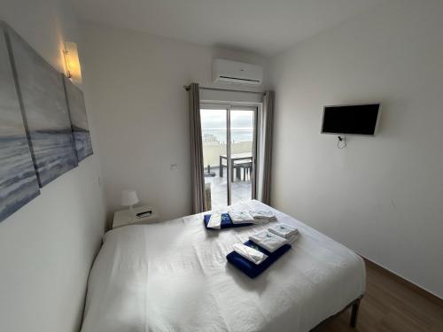 a bedroom with a bed with two towels on it at Magnolia Mar Apartamentos in Lagos