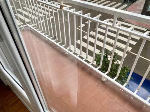 a white railing on a balcony with a plant at Pensión el Horno in León
