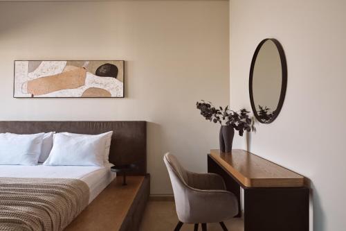 a bedroom with a bed and a desk and a mirror at Vorto Luxury Villas, a Signature Island Retreat, By ThinkVilla in Zakynthos