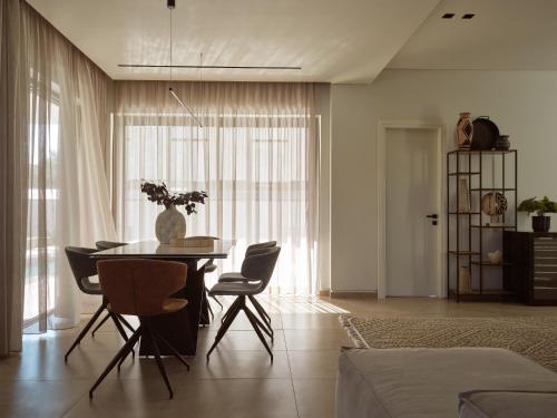 a living room with a dining room table and chairs at Vorto Luxury Villas, a Signature Island Retreat, By ThinkVilla in Zakynthos