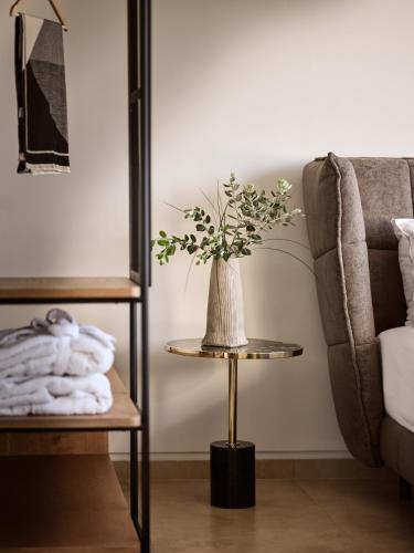 a vase of flowers on a table next to a couch at Vorto Luxury Villas, a Signature Island Retreat, By ThinkVilla in Zakynthos