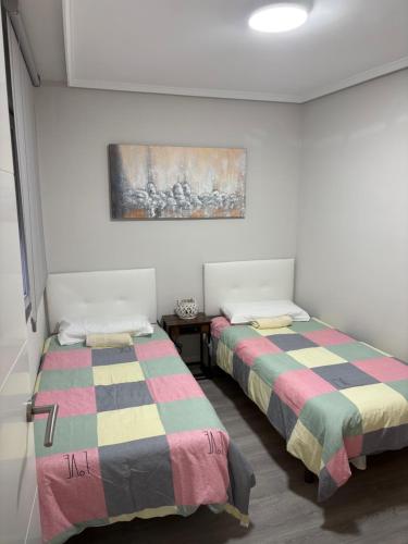 two beds sitting next to each other in a room at Piso barrio romántico in León