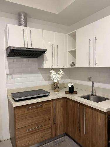 a kitchen with white cabinets and a sink at Matina Enclaves Residences in Davao City