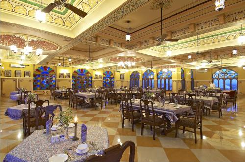a dining room with tables and chairs and stained glass windows at Welcomhotel by ITC Hotels, Fort & Dunes, Khimsar in Khimsar