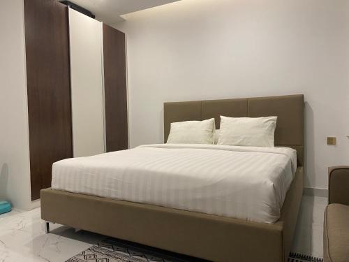 a bedroom with a large bed with white sheets and pillows at The Vincent Apartment in Phnom Penh