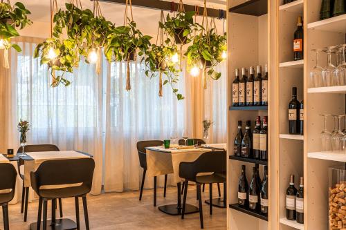 een restaurant met tafels en stoelen en flessen wijn bij Cà Del Pioppo in Cavallino-Treporti