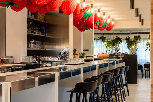 een bar in een restaurant met zwarte stoelen en rode kroonluchters bij Cà Del Pioppo in Cavallino-Treporti