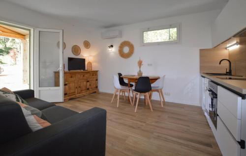 un salon avec un canapé et une table avec des chaises dans l'établissement Charmant T2 à la campagne, à Riventosa