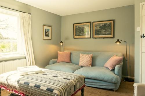 a living room with a blue couch with pink pillows at Fritton Lake - The Clubhouse in Great Yarmouth