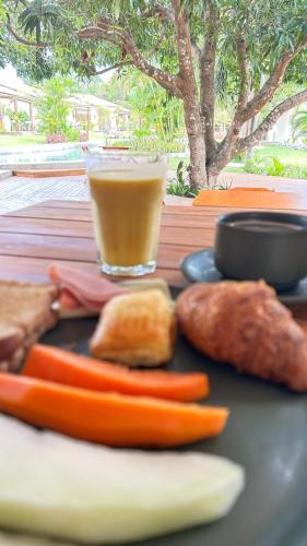 a tray with vegetables and a drink on a table at La Belle Resort Lago Azul in Nísia Floresta
