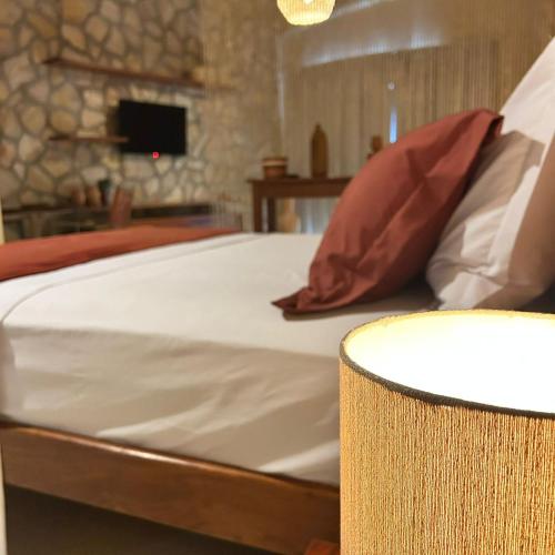 a bed with white sheets and red pillows in a room at La Belle Resort Lago Azul in Nísia Floresta