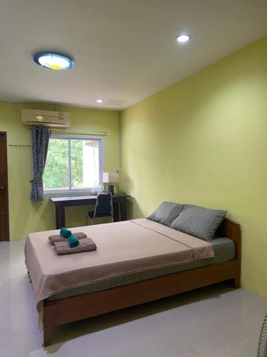 a bedroom with a bed and a desk and a window at Jack's house Thara in Krabi