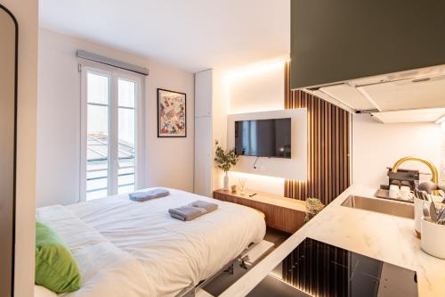 une chambre avec un grand lit et un lavabo dans l'établissement Stunning Tiny Studio - 5 min to Eiffel Tower - Sleeps 2P, à Paris
