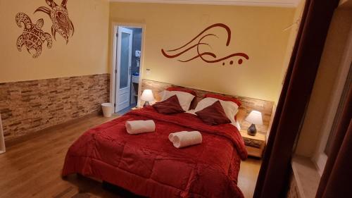 a bedroom with a red bed with two pillows at Ocean Tree Ferrel in Peniche