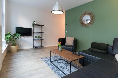 a living room with a couch and a table at Alkmaar City Apartments in Alkmaar