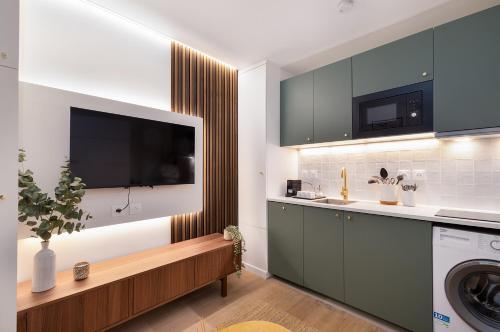 Il comprend une cuisine équipée d'un lave-linge et une télévision. dans l'établissement Stunning Tiny Studio - 5 min to Eiffel Tower - Sleeps 2P, à Paris