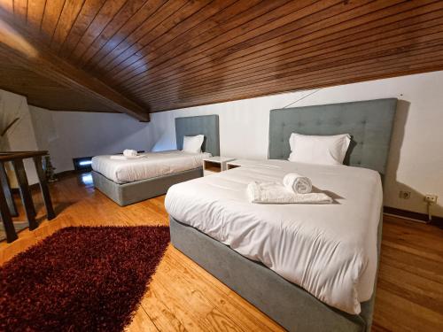 a bedroom with two beds and a red rug at Casa Cogumelo Beachfront Retreat in Viana do Castelo