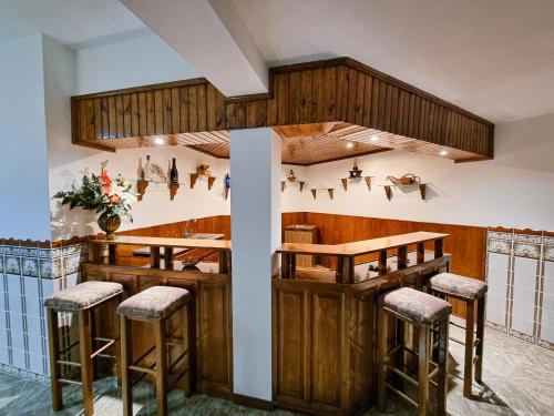 a bar in a restaurant with wooden walls and stools at Casa Cogumelo Beachfront Retreat in Viana do Castelo