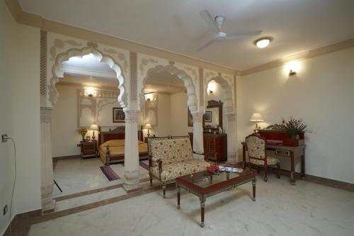 a living room with a couch and a bed and a table at Welcomhotel by ITC Hotels, Fort & Dunes, Khimsar in Khimsar