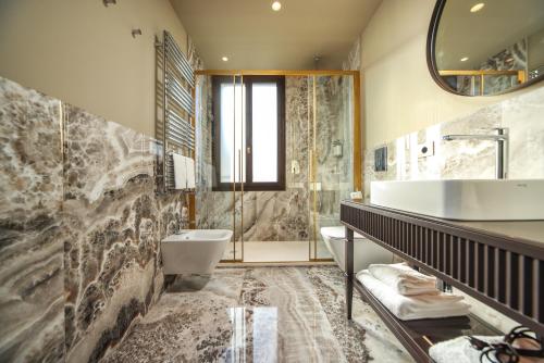 a bathroom with a sink and a toilet and a tub at U-Visionary Venezia Hotel in Venice