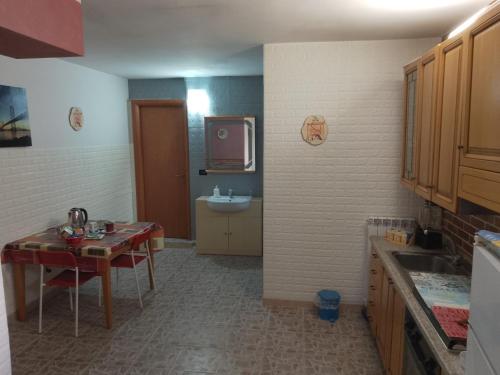 a kitchen with a table and a sink and a tv at taverna francesco in Orbassano