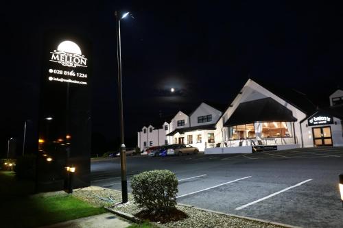 a sign for a restaurant on a street at night at Mellon Country Inn Hotel in Omagh