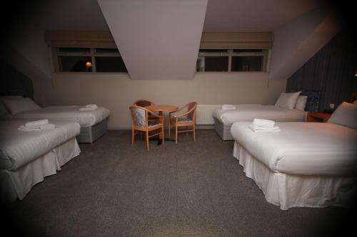 a room with beds and a table and chairs at Mellon Country Inn Hotel in Omagh
