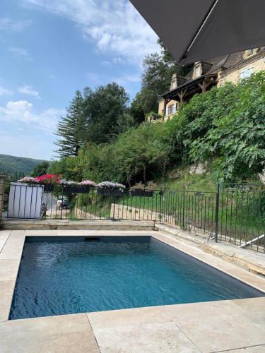 une piscine en face d'une clôture dans l'établissement Grande maison avec piscine sous les falaises de La Roque Gageac, à Vézac