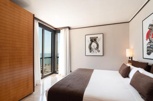 a bedroom with a bed and a large window at Estela Barcelona in Sitges