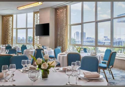 a conference room with tables and chairs and windows at شقة فندقية - كورنيش المعادي تاور ريزيدنت in Cairo
