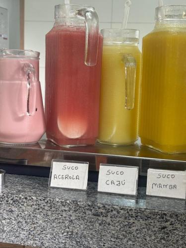 a row of different types of juices on a counter at Pousada O Sol De Maragogi in Maragogi