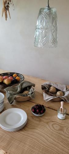 MarstalにあるAtma Guesthouse - cozy and simple farmhouse bed & breakfastの木製テーブル(皿、果物入り)