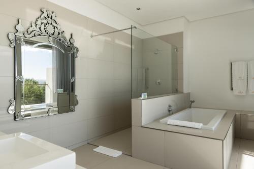 a white bathroom with a sink and a mirror at Benguela Cove - Lavender Dreams in Hermanus