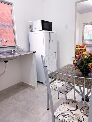 a kitchen with a white refrigerator and a table at Cantinho #1 Espaço Inteiro in Ilhéus