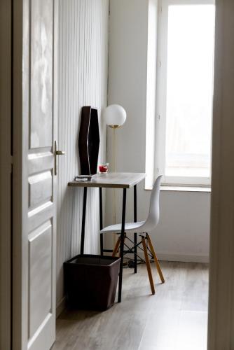 une table et une chaise dans une pièce avec une fenêtre dans l'établissement L'Espoir avec belle vue - Centre de Vienne, à Vienne