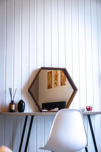 un miroir sur une table avec une chaise blanche dans l'établissement L'Espoir avec belle vue - Centre de Vienne, à Vienne