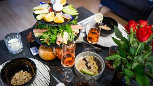 a table topped with plates of food and drinks at Apartment Passau C - Gargen, Stilvoll, Modern & Cozy im Zentrum von Passau in Passau