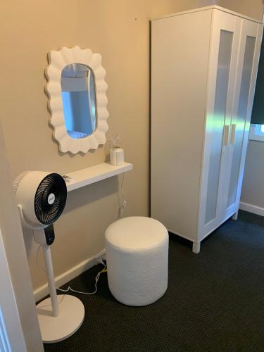 a bathroom with a hair dryer and a mirror at Lucky Charm Cottage in Manjimup