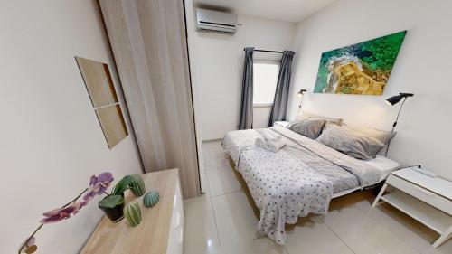 une petite chambre avec un lit et un miroir dans l'établissement Urban Family Retreat Modern Apartment With BBQ, à San Ġiljan
